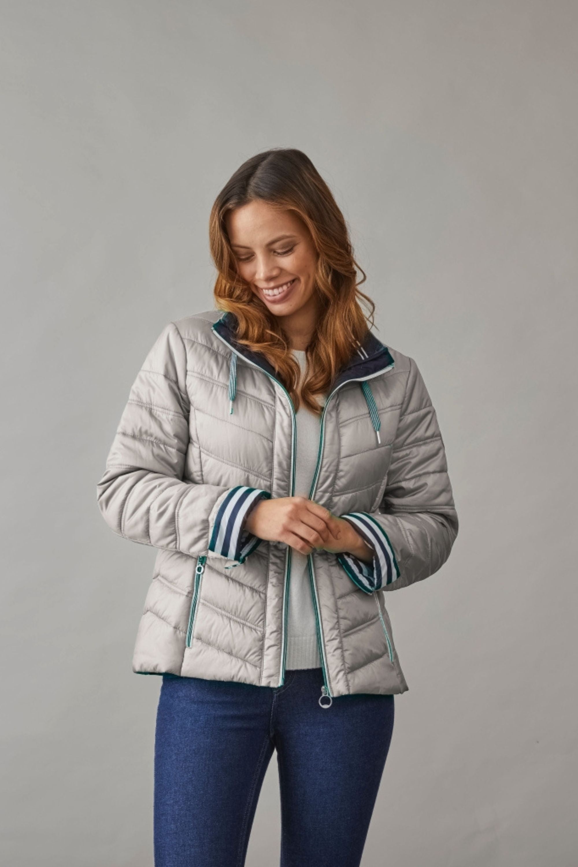 Woman wearing a lightweight ladies spring quilted jacket in silver-grey with striped cuffs, perfect for layering in transitional weather.
