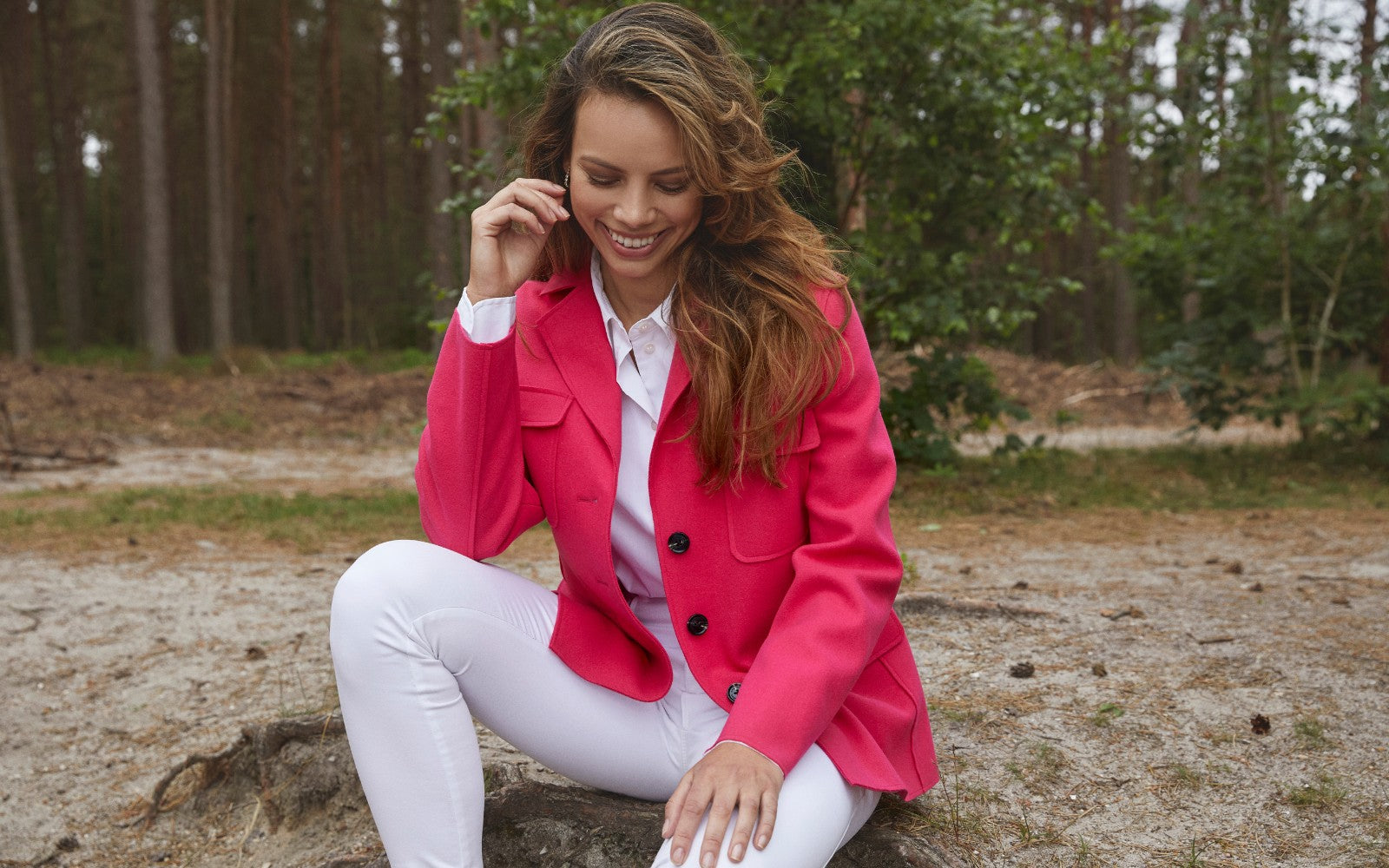 Woman wearing a vibrant pink short spring jacket for women, styled with white trousers—lightweight and trendy for 2025.